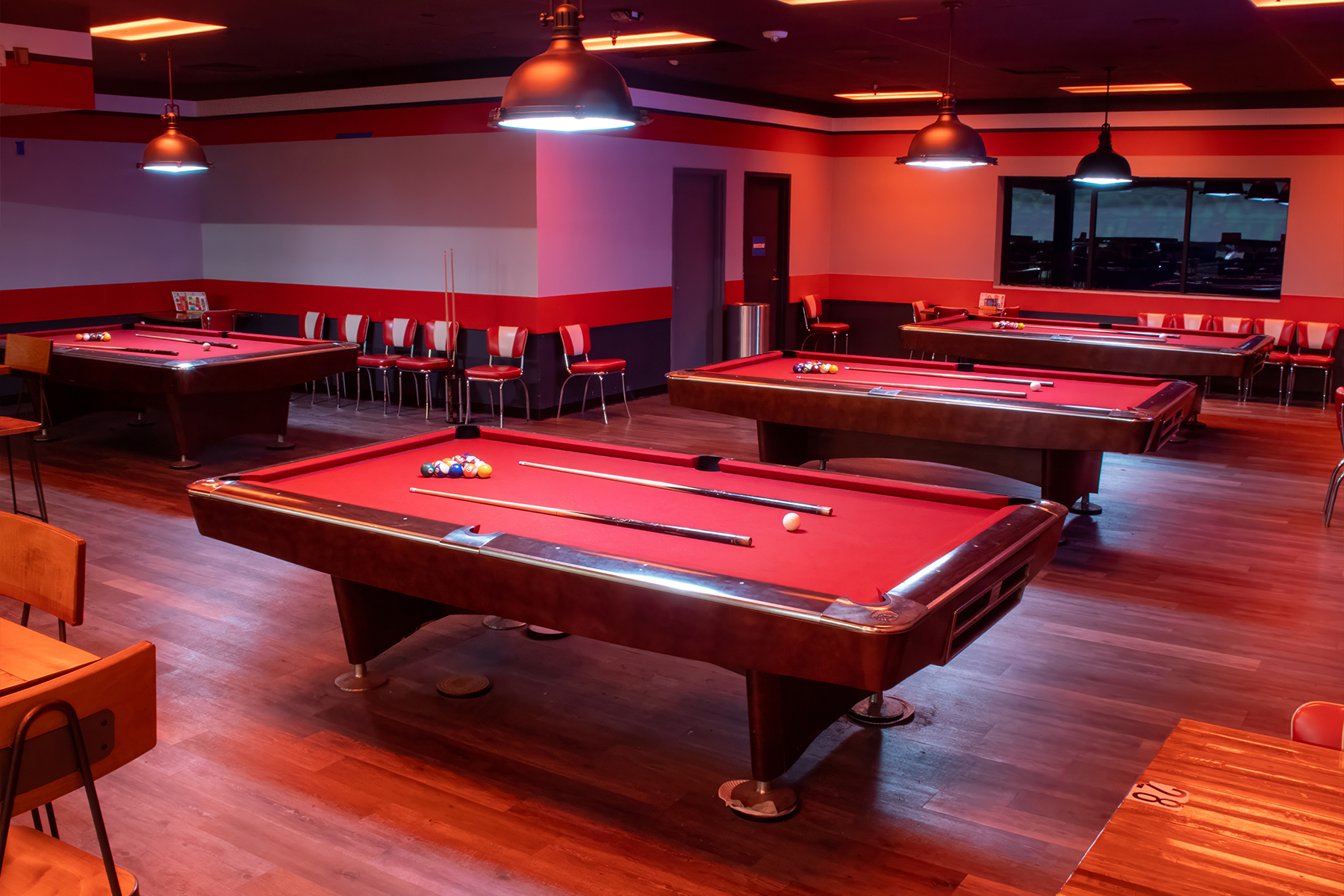 Red billiards table a large room with a classic wood floor.
