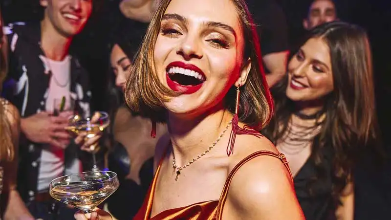 Woman enjoying champagne at Lucky Strike party.