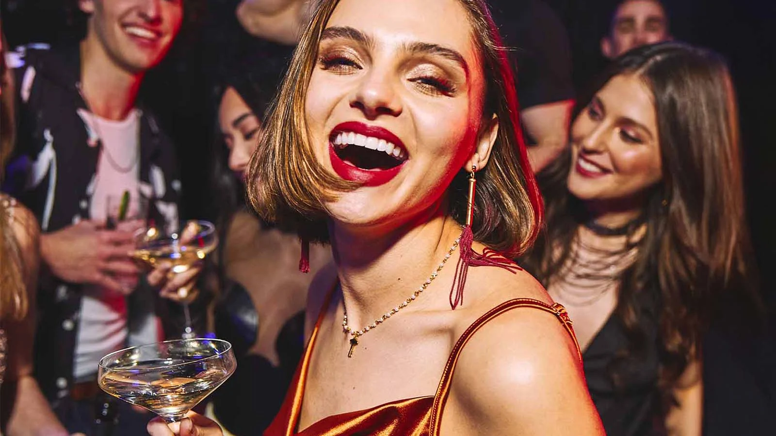 Woman enjoying champagne at Lucky Strike party.