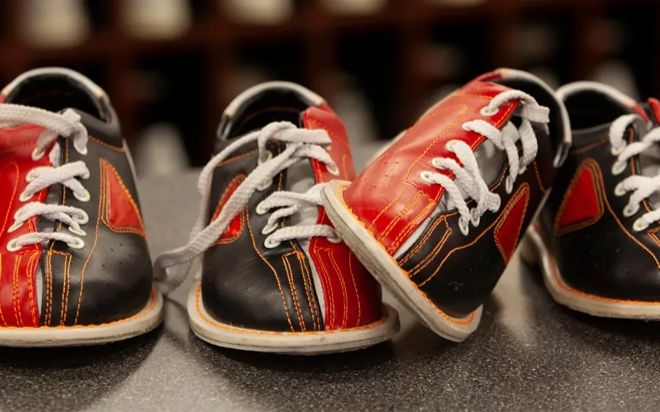 Two pairs of red and black bowling shoes.