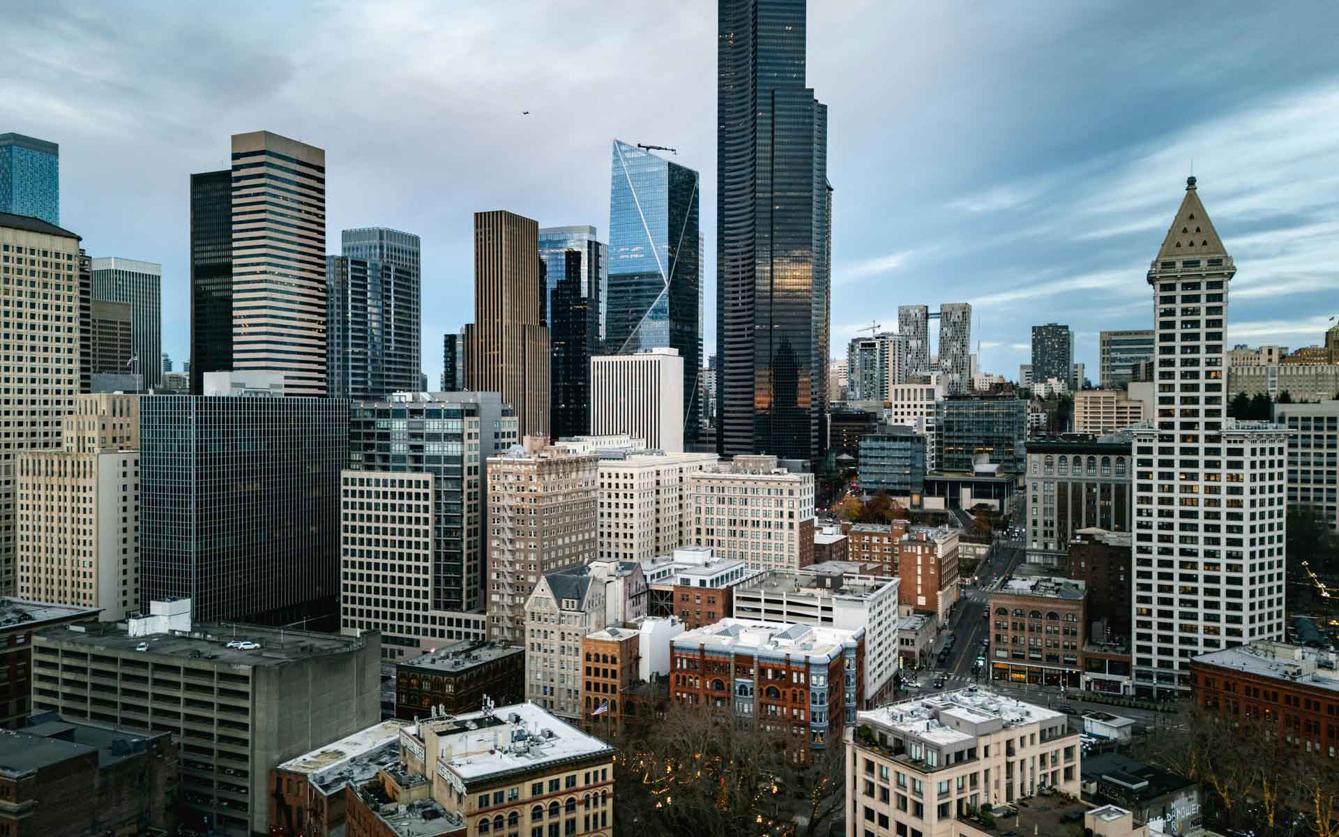 Seattle skyline with downtown skyscrapers, urban architecture, and cloudy Pacific Northwest atmosphere.