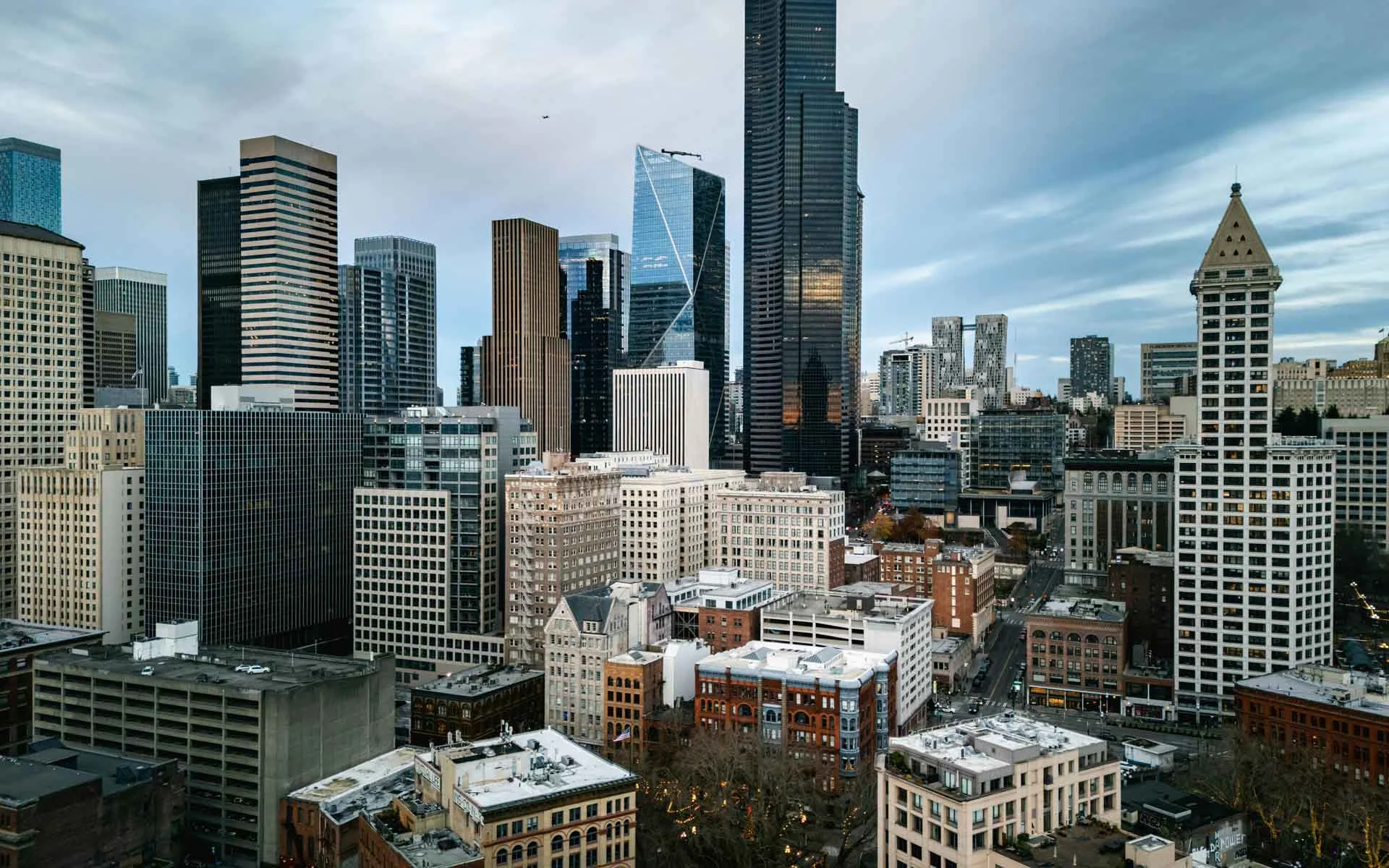 Seattle skyline with downtown skyscrapers, urban architecture, and cloudy Pacific Northwest atmosphere.