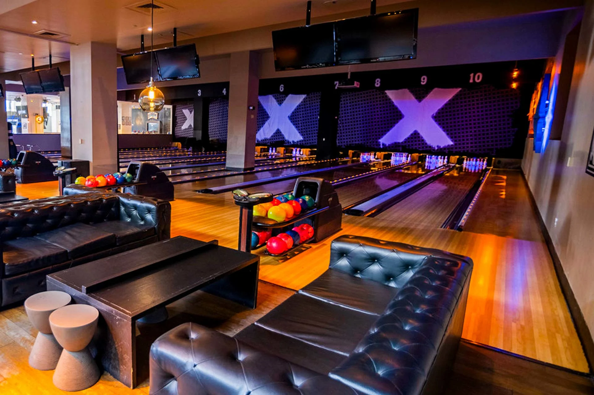 Lucky Strike San Francisco's upscale bowling lounge with leather seating, polished lanes, glowing pins, and overhead screens in a modern, social atmosphere.