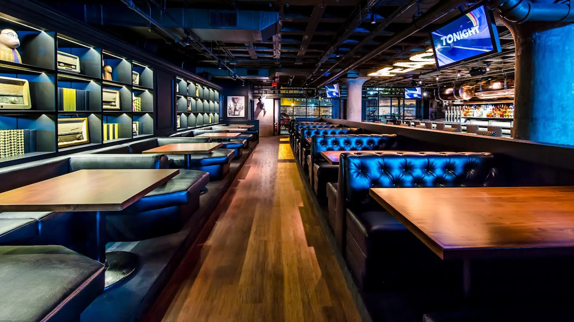Cheeky Monkey dining area with leather booths, wood tables, and retro wall displays.