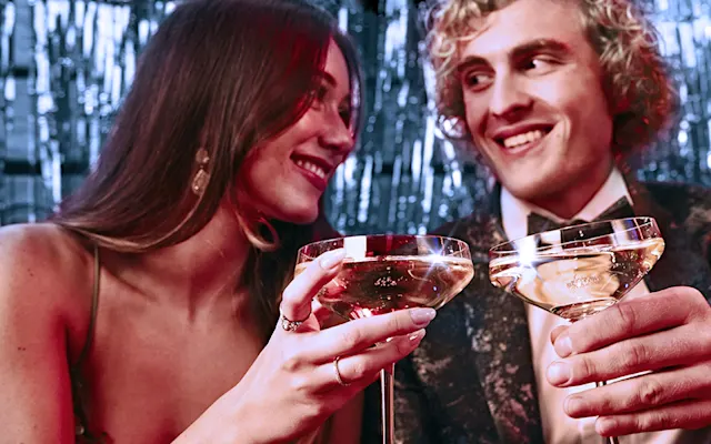 Formally dressed man and woman toasting champagne 