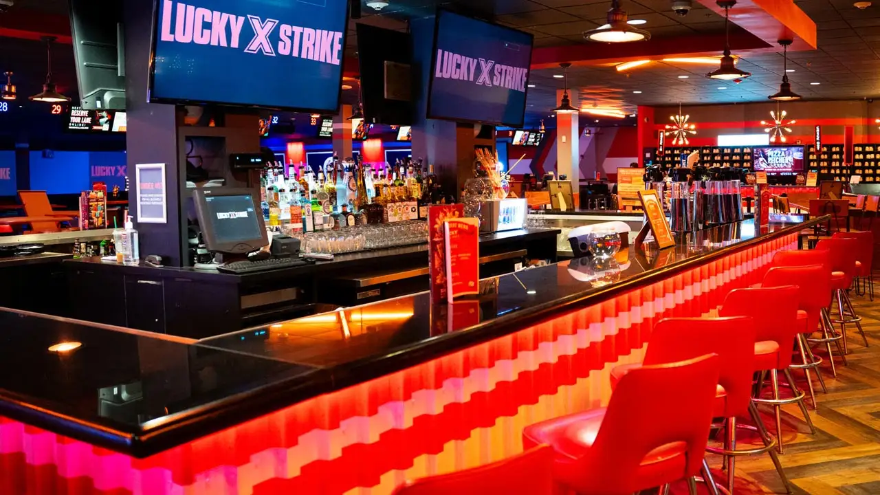 Beautiful bar with lots of seating and large TV screens above the bar