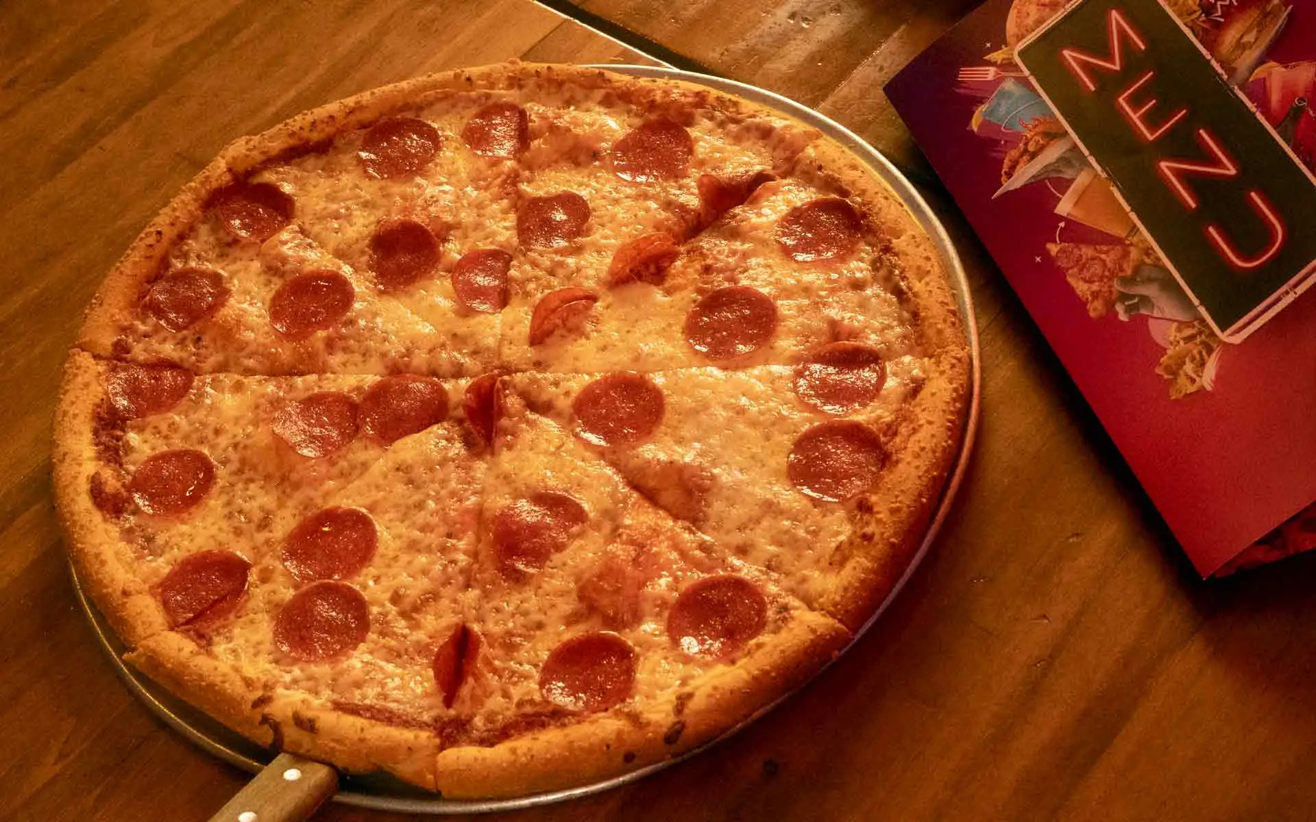 Pepperoni pizza served at AMF bowling center with a menu in the top right corner.