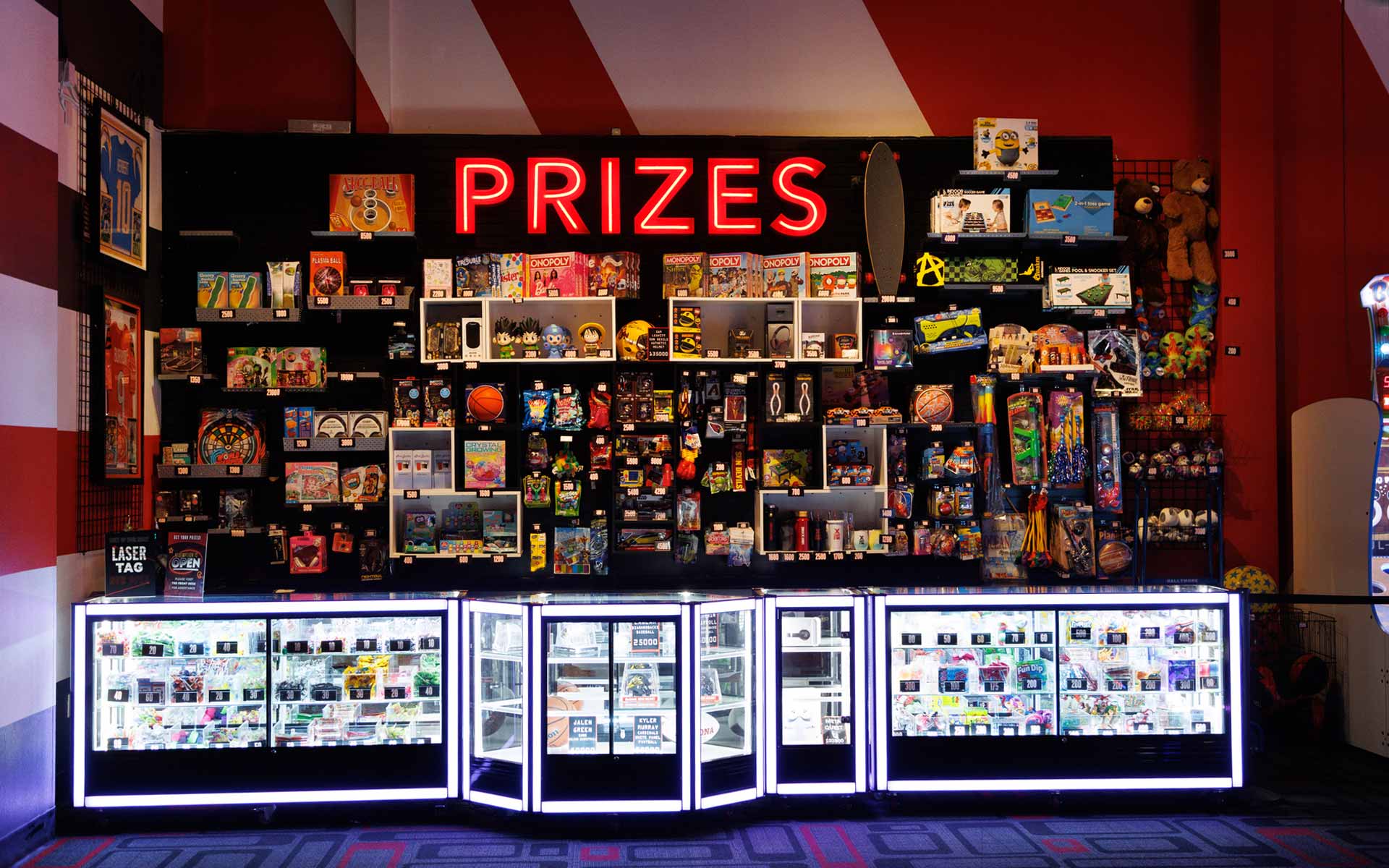 Bright, engaging redemption area stocked with a wide variety of prizes—from toys and games to premium items. Features illuminated display cases and a clean, organized layout that encourages repeat play and rewards engagement.