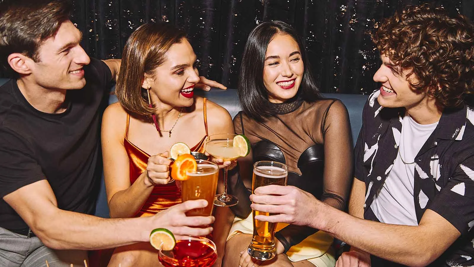 Group of four adults having fun and enjoying drinks