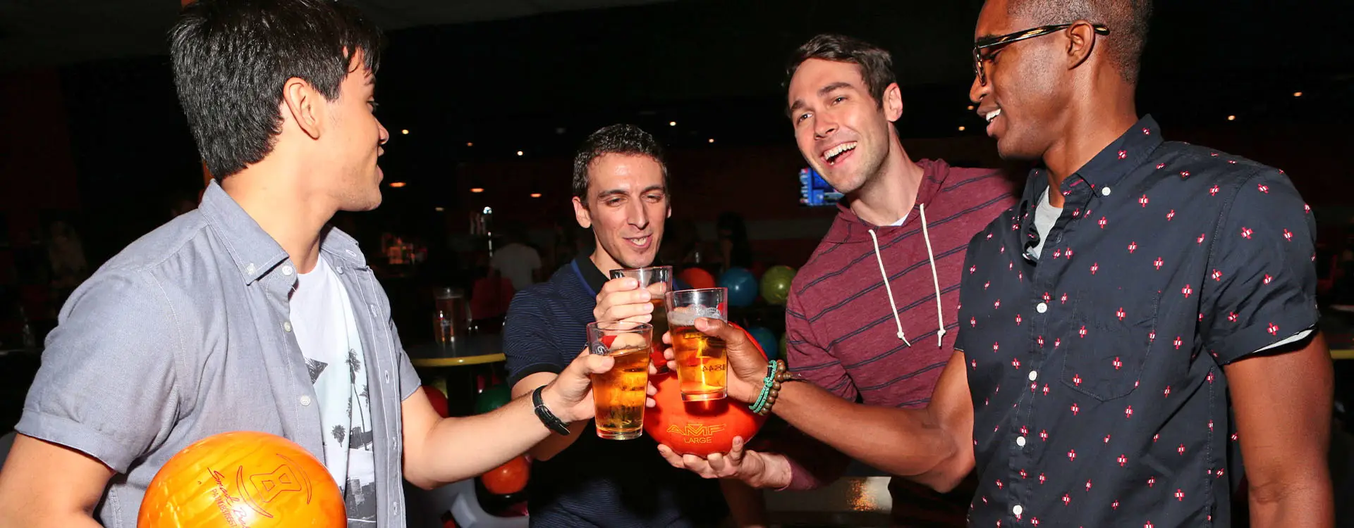 Four bowling league players with drinks and having fun
