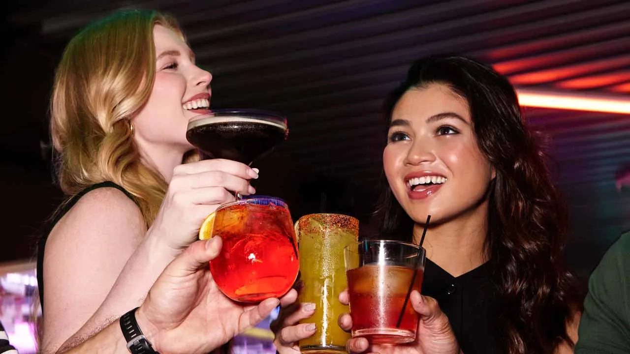A group of friends cheersing with cocktails.