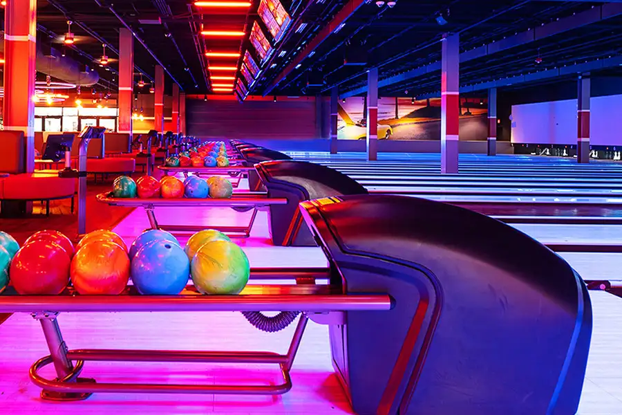 Colorful bowling balls lined up on bowling ball rack returns.
