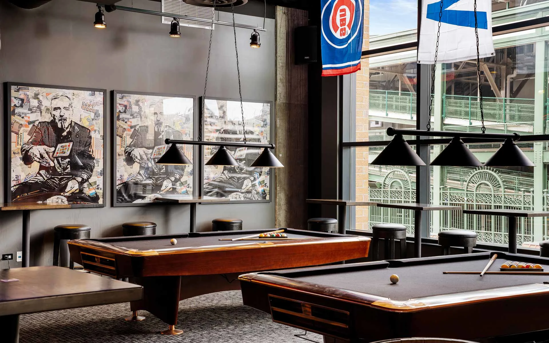 Upscale billiards lounge with pool tables, pendant lighting, wall art, and large windows in a modern Lucky Strike entertainment venue.