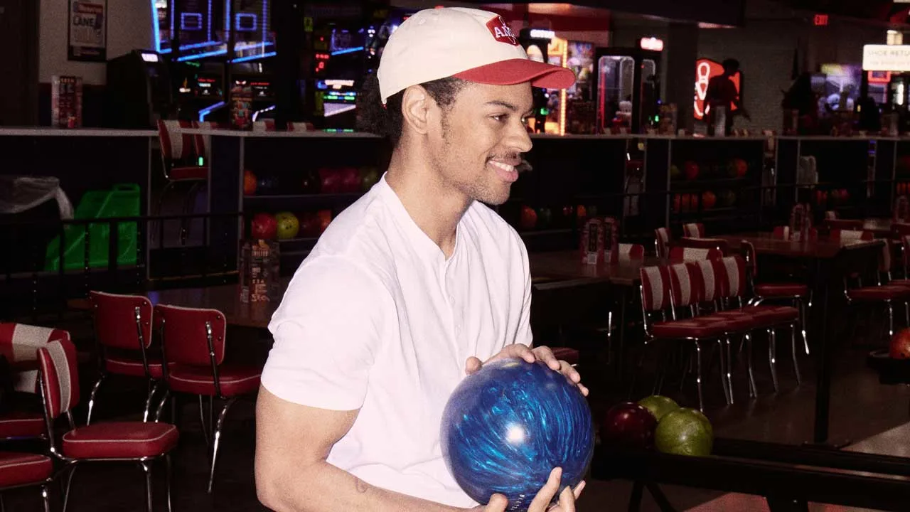 Man holding bowling ball on the lane approach of an AMF center.