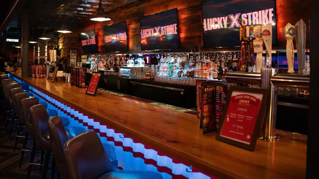 Beautiful bar with lots of seating and large TV screens above the bar