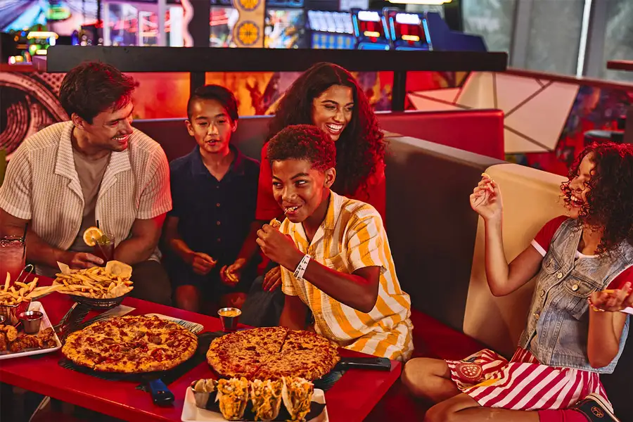Group of kids and adults enjoying pizza, fires, and tacos.