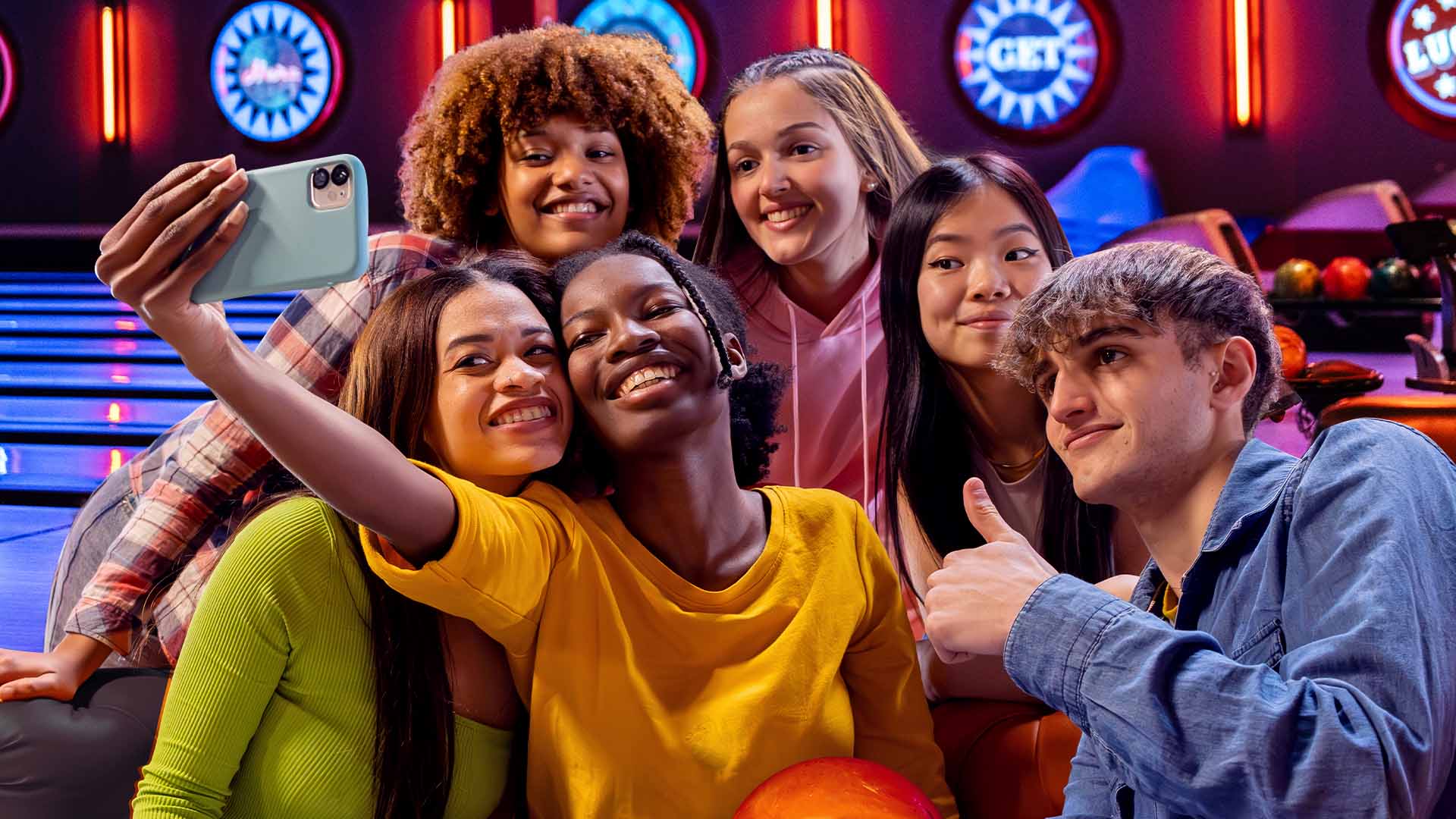 Group of teens taking a selfie with bowling lanes in the background