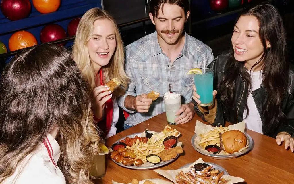 Friends eating and drinking at an AMF bowling center