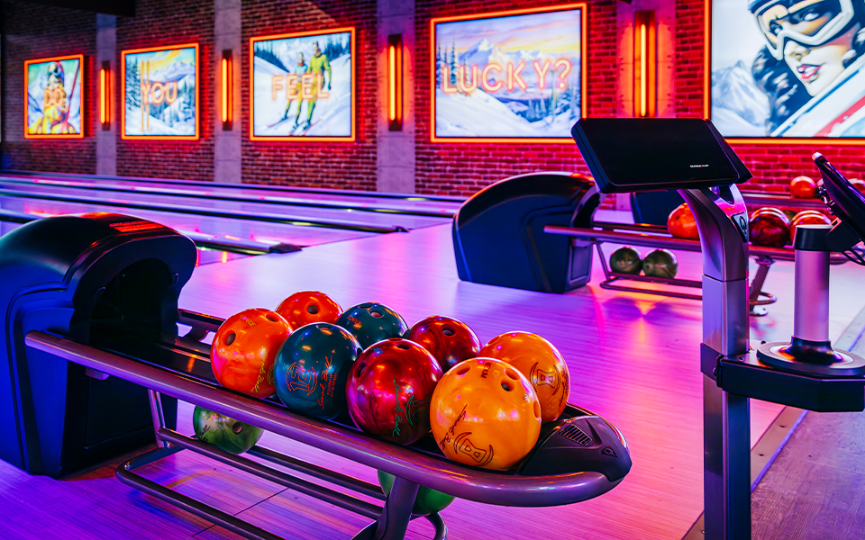 Colorful bowling balls and empty bowling lanes.