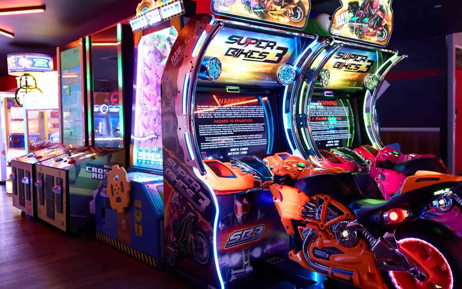 Super Bikes 3 and Crossroads arcade racing games glowing in neon at Lucky Strike Los Angeles arcade