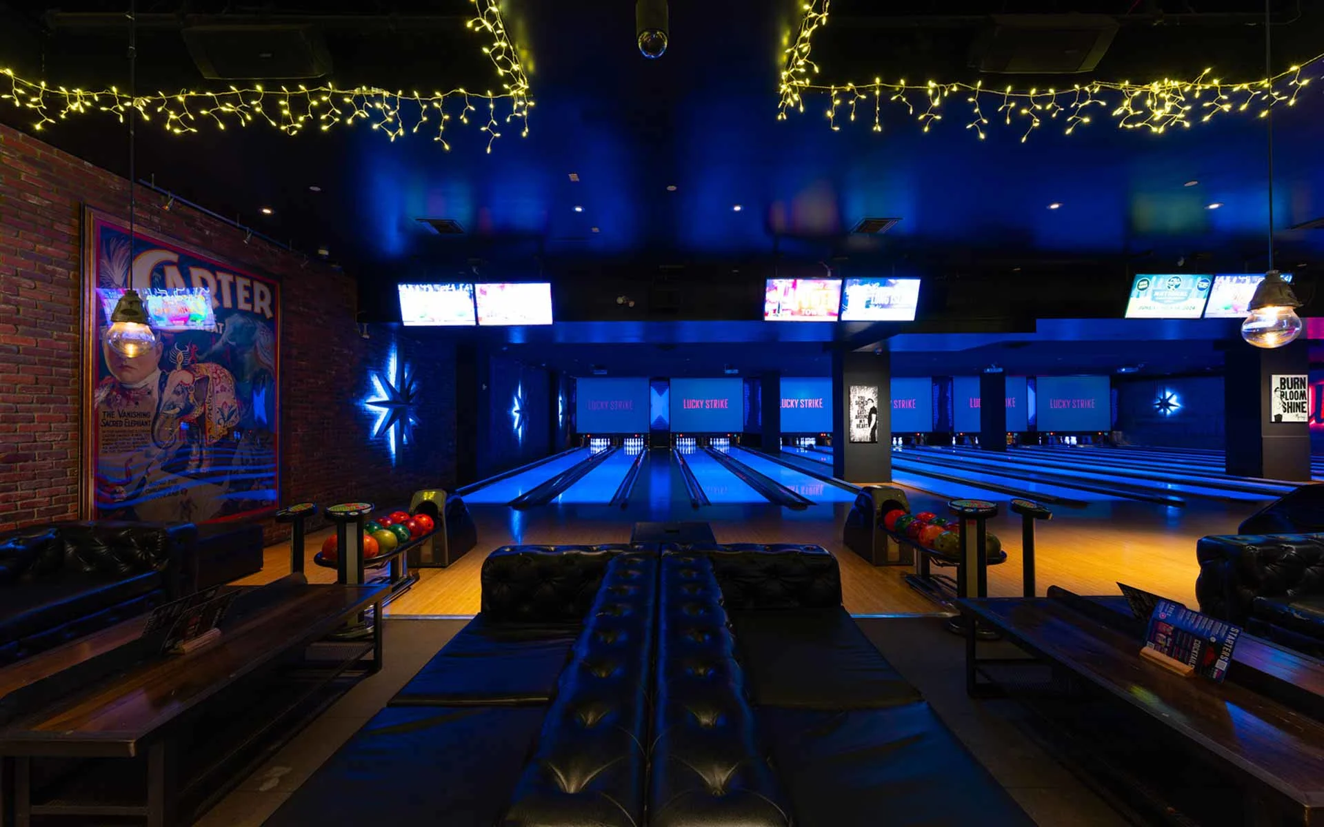 Modern bowling lanes framed by plush leather seating and warm accent lighting. The intimate layout creates a more exclusive feel, perfect for small groups, date nights, or VIP-style experiences.