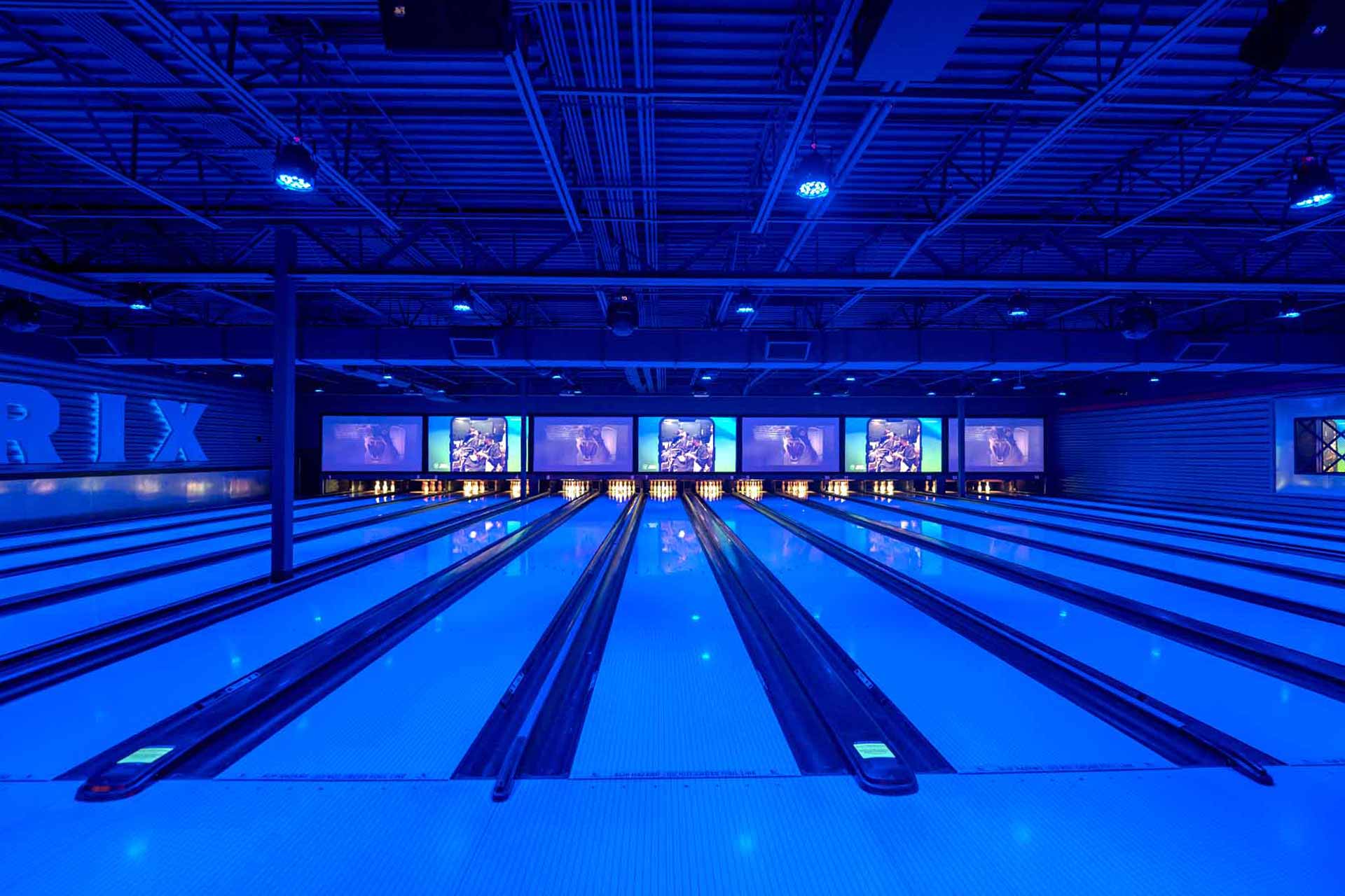 Modern bowling lanes at Mavrix Entertainment Center with blue lighting and digital screens.