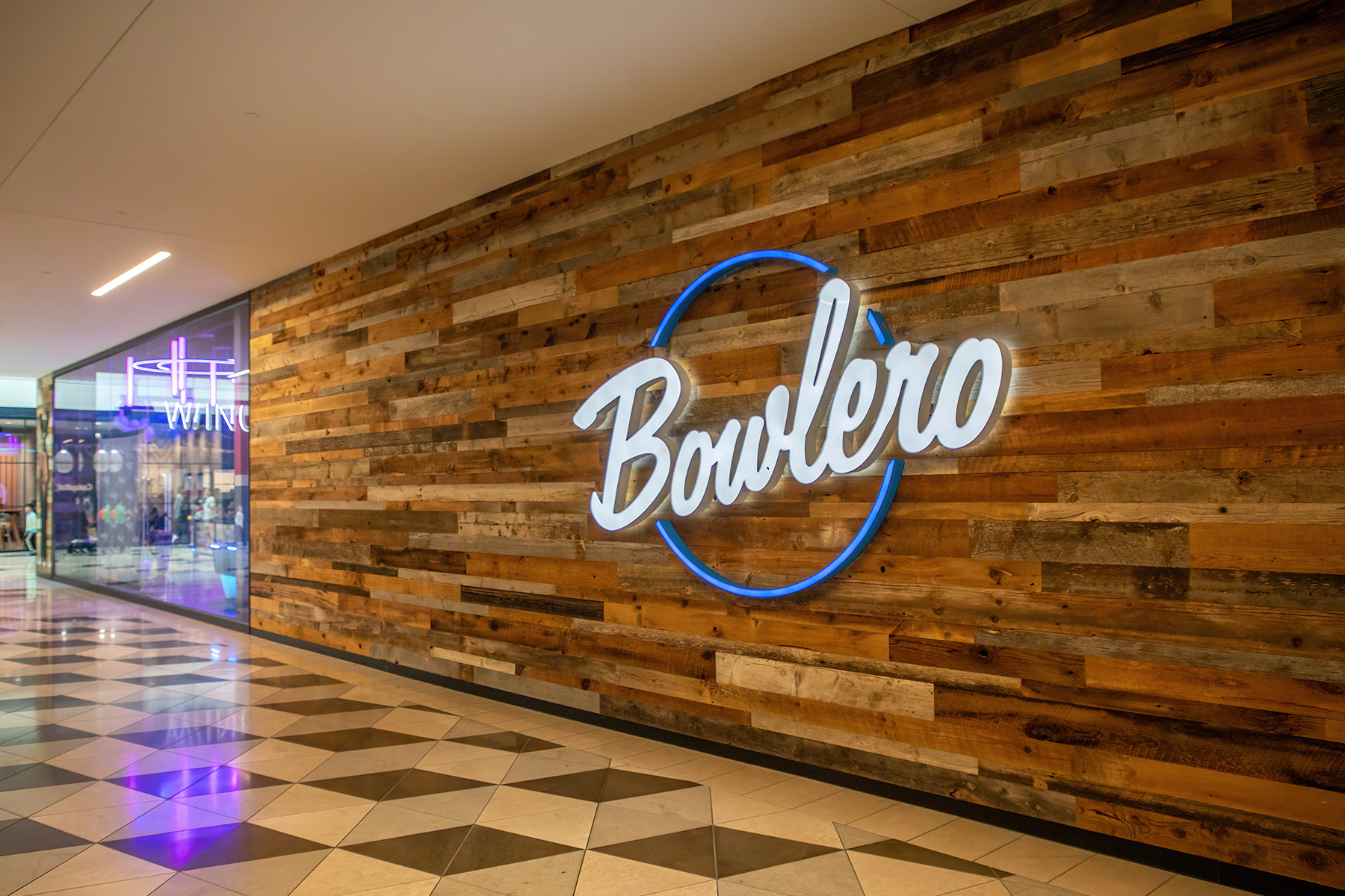 Large neon Bowlero sign on gorgeous wood wall