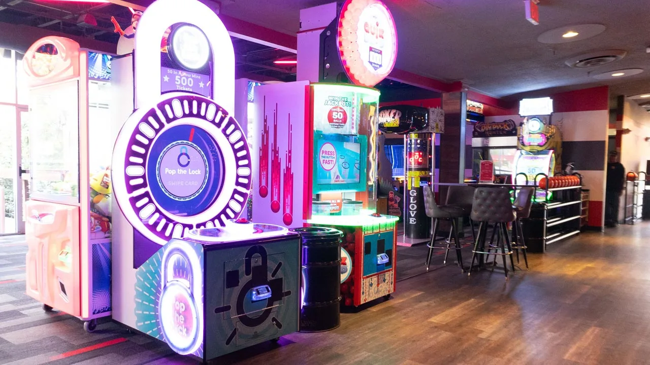 Large and colorful arcade games with a dining area in the background.