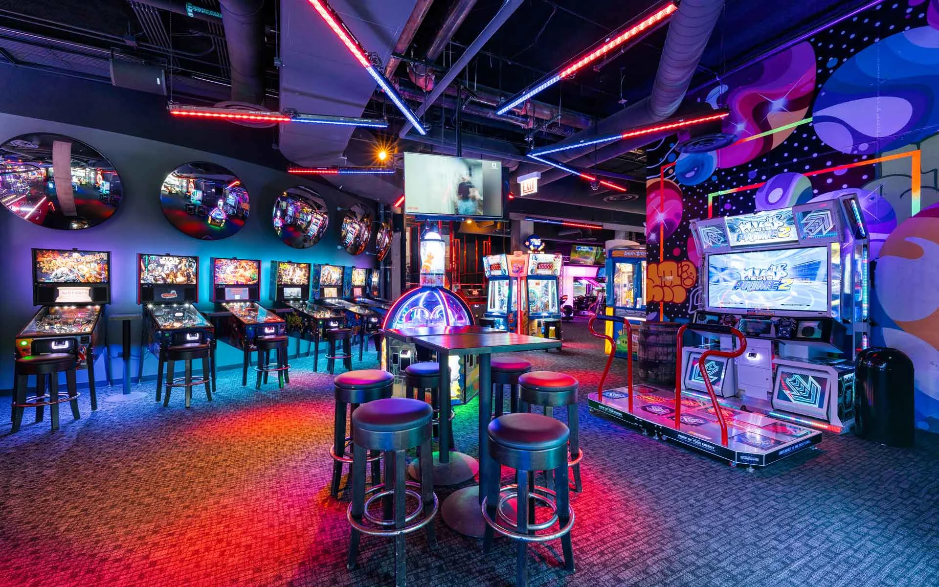 Colorful arcade area with neon lighting, classic and modern games, and interactive attractions at a Lucky Strike location.