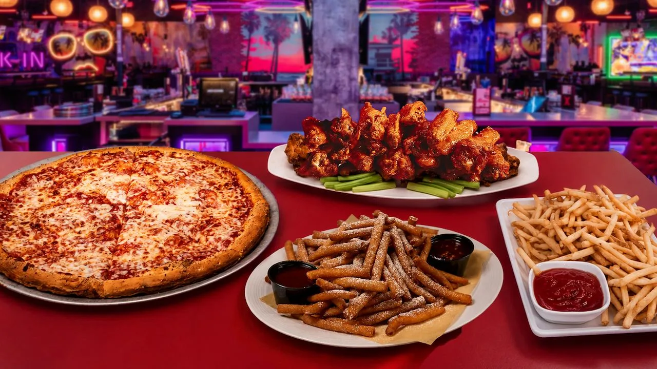 A table filled with fresh, delicious party food and a colorful bar in the background.