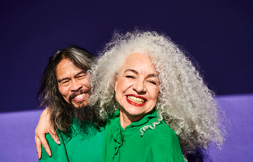 Two people in green smiling