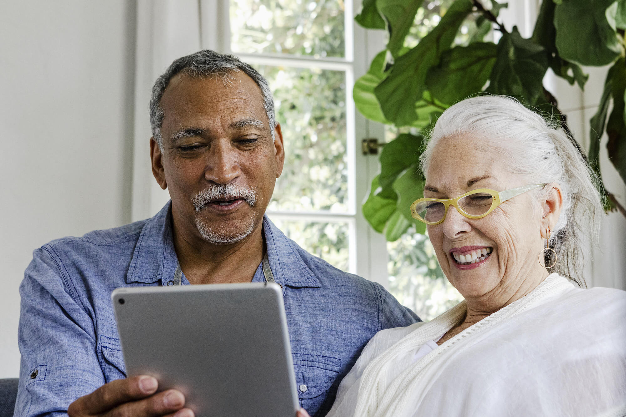 Woman and man smiling at tablet