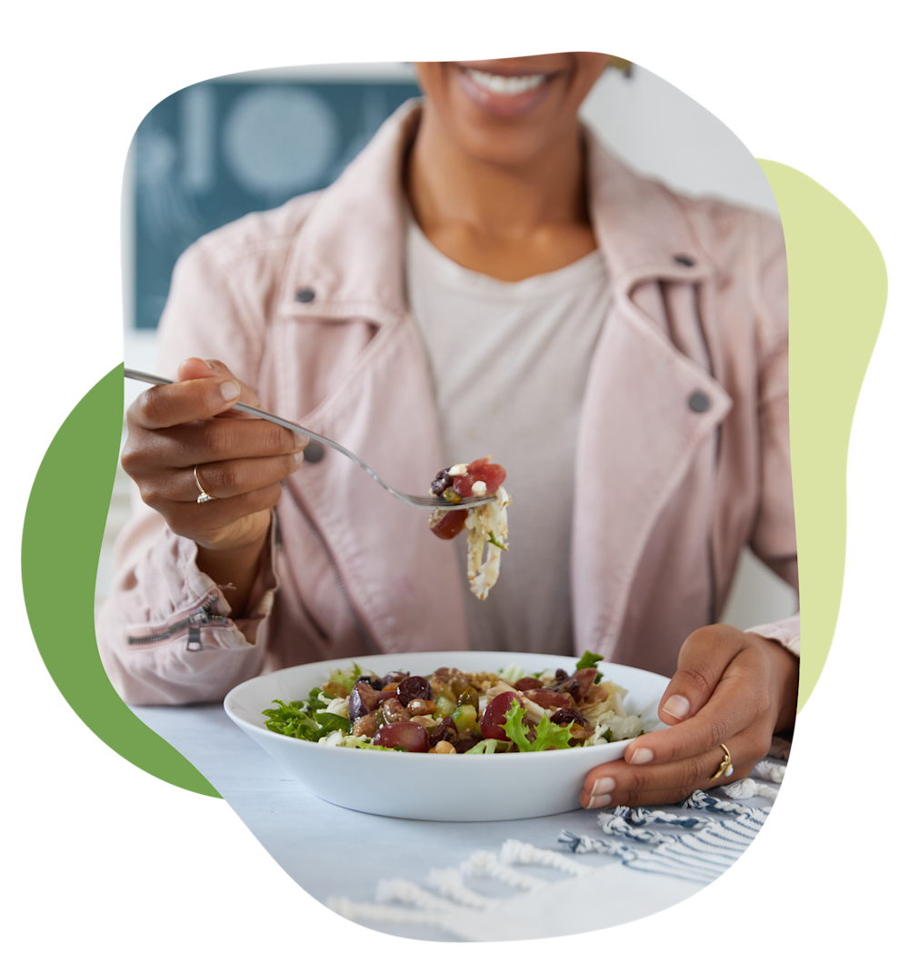 Woman eating a Farmer's Fridge salad out of a bowl.
