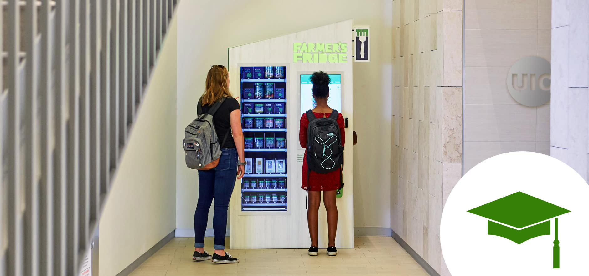 Two students standing in front of a Farmer's Fridge on their campus.