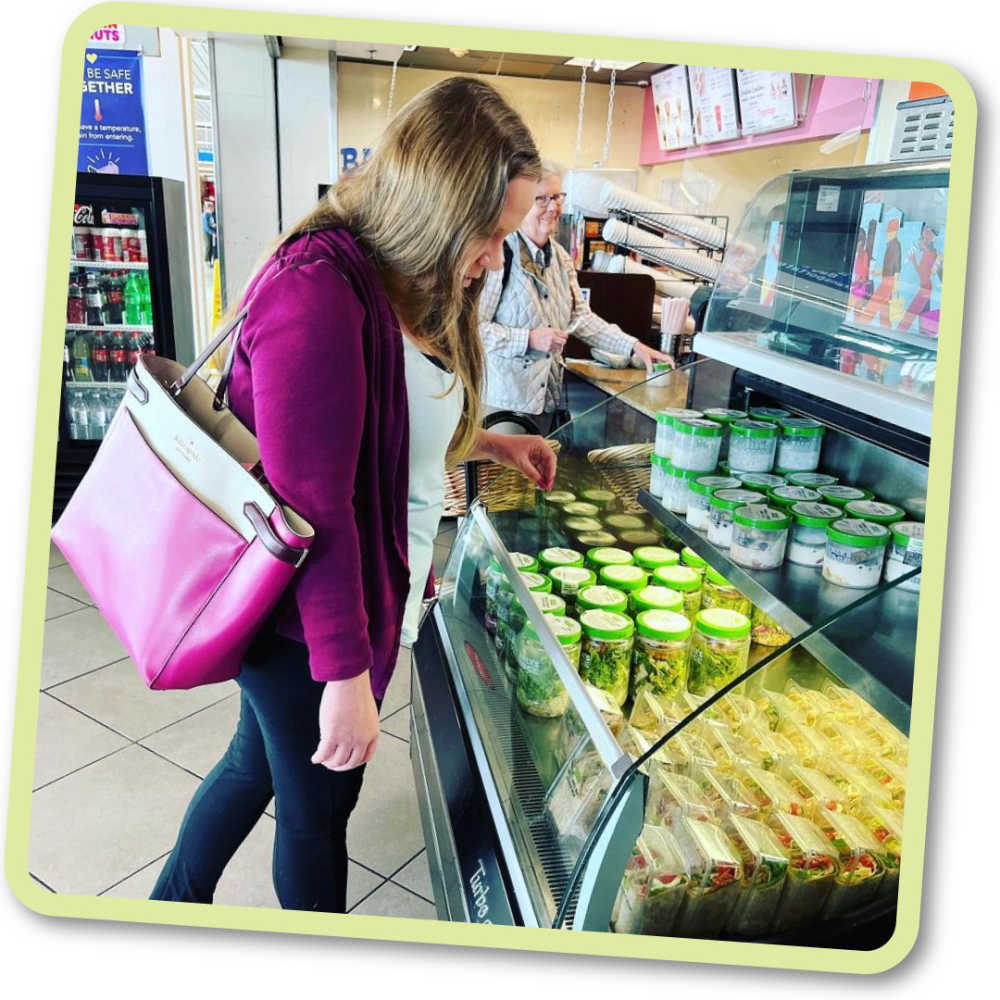 Woman looking at Farmer's Fridge meals in a grocery store