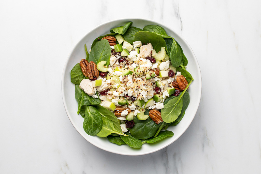 An overhead shot of an apple pecan salad in a bowl. 