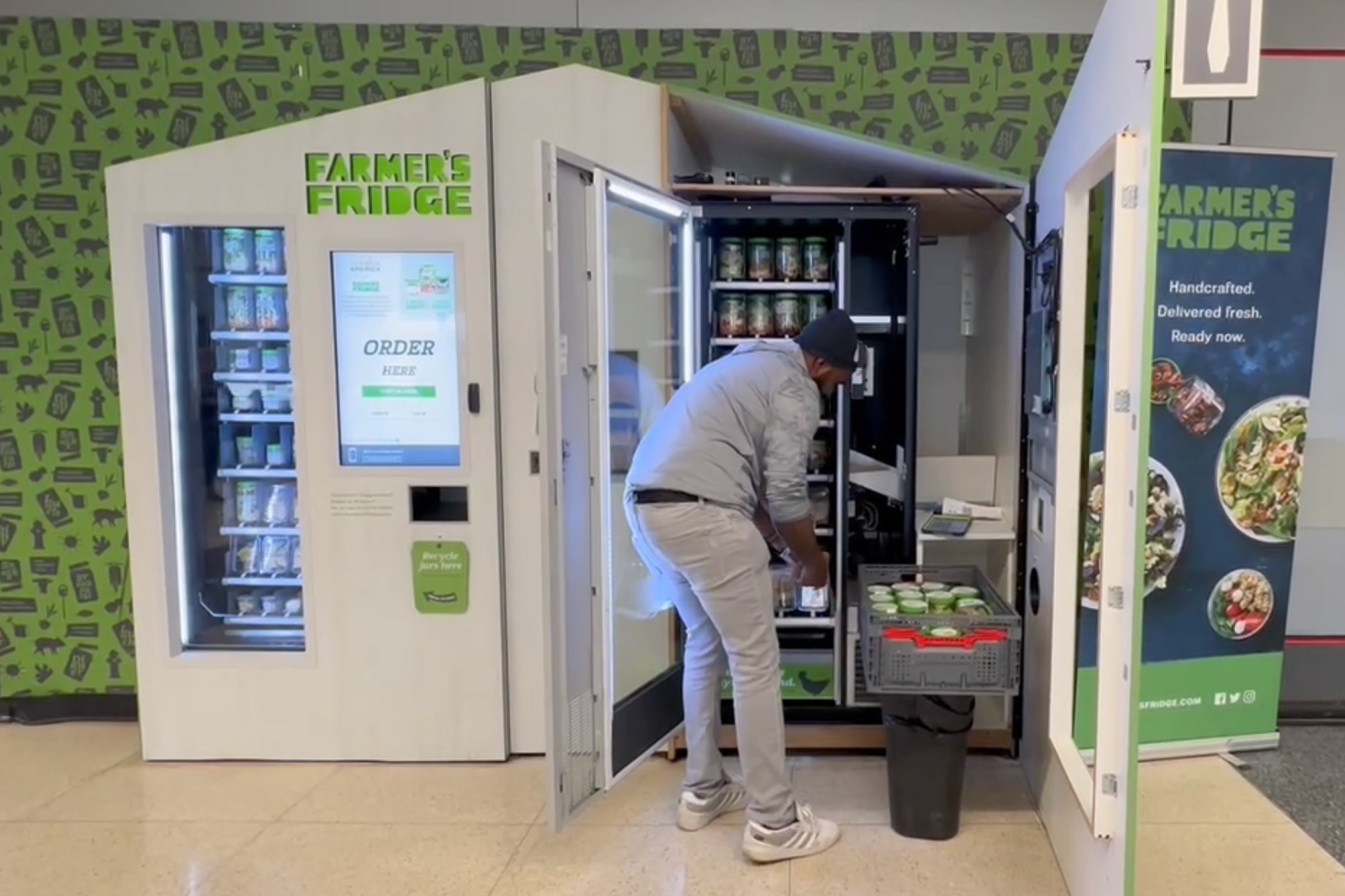 A Farmer's Fridge delivery driver stocking a Fridge.