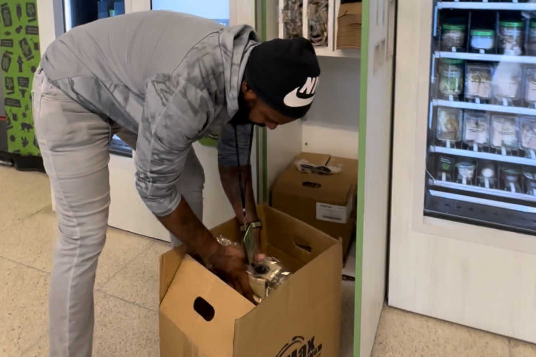 A Farmer's Fridge delivery driver refilling the utensils at a Fridge.