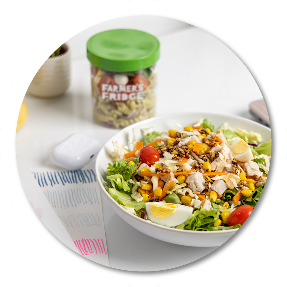 Various Farmer's Fridge menu items in jars and packaging on a table