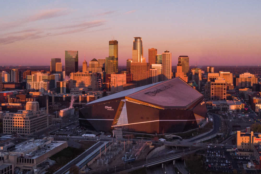 Photo of downtown Minneapolis with Vikings stadium in the foreground.