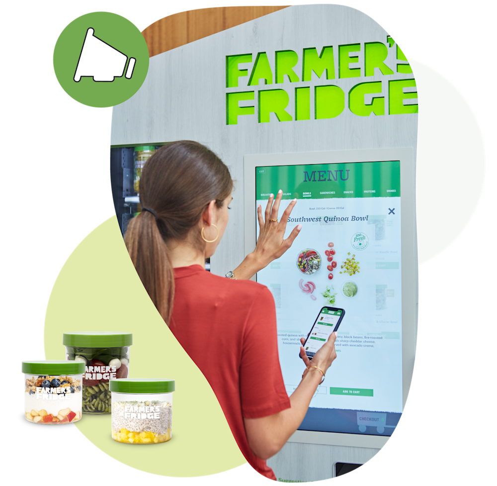 A woman using the touch screen menu of a Farmer's Fridge.