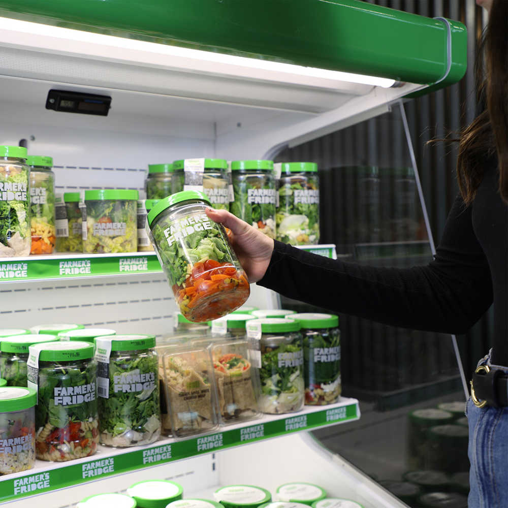 Image of a hand holding a jar of salad