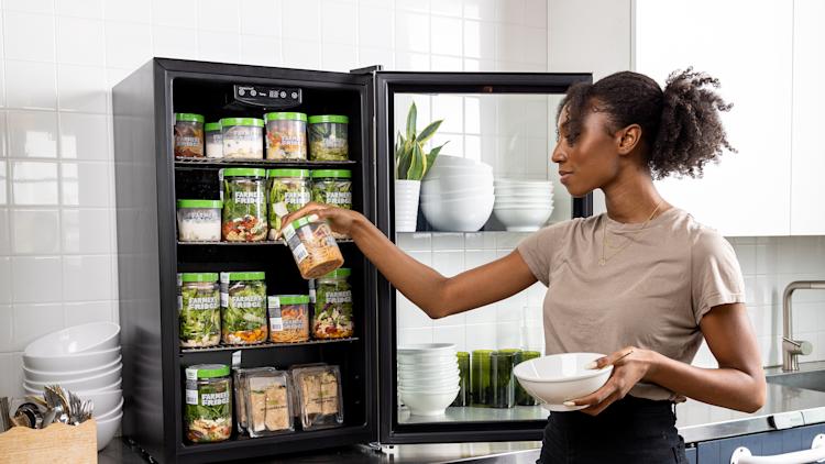 Woman grabbing Farmer's Fridge out of a refrigerator