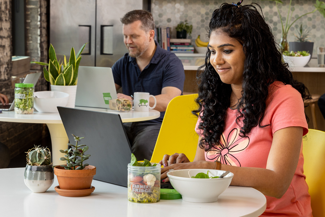 Image of coworkers eating Farmer's Fridge on their lunch break.