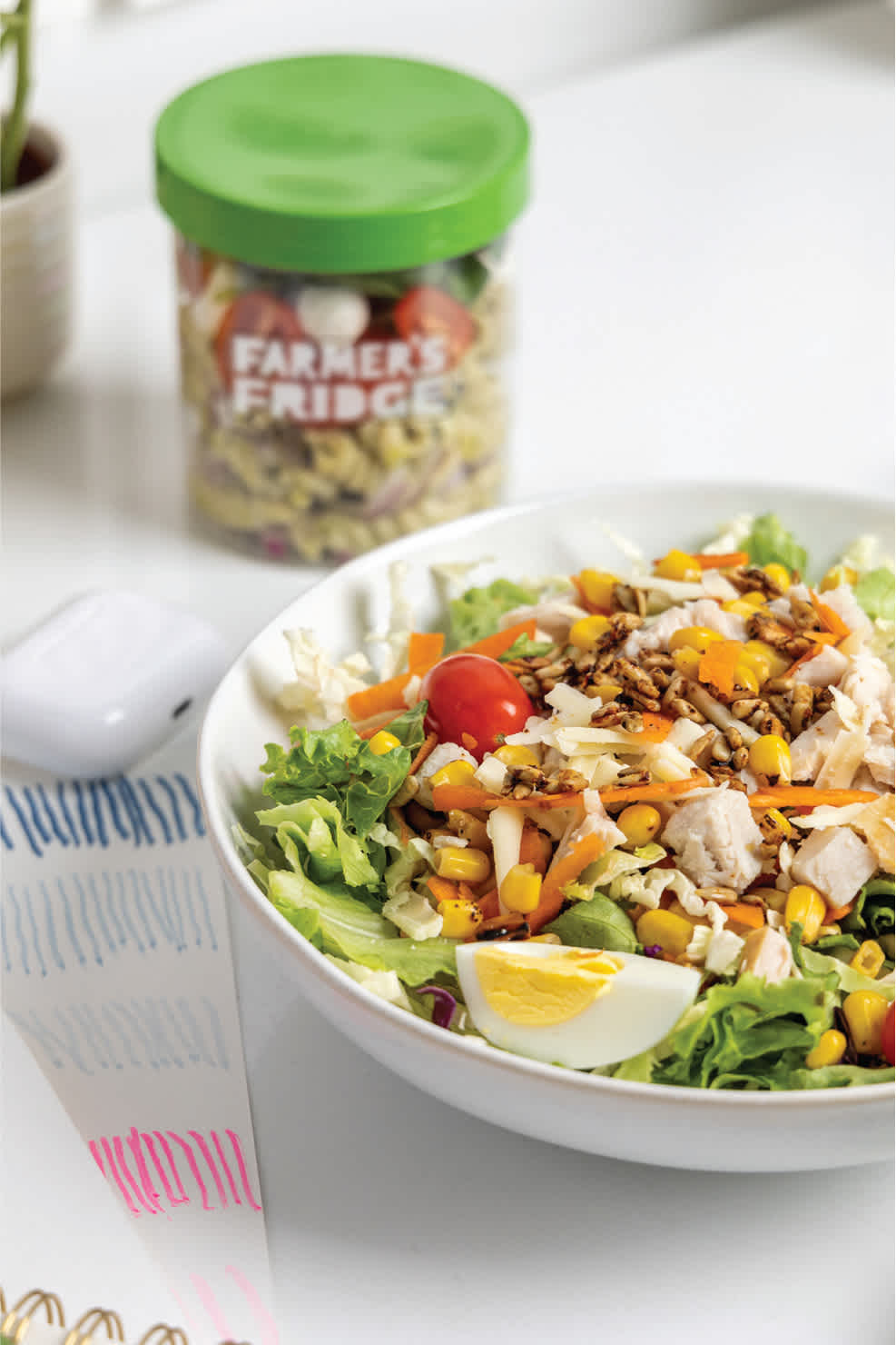 Image of a salad and a jar sitting on a desk