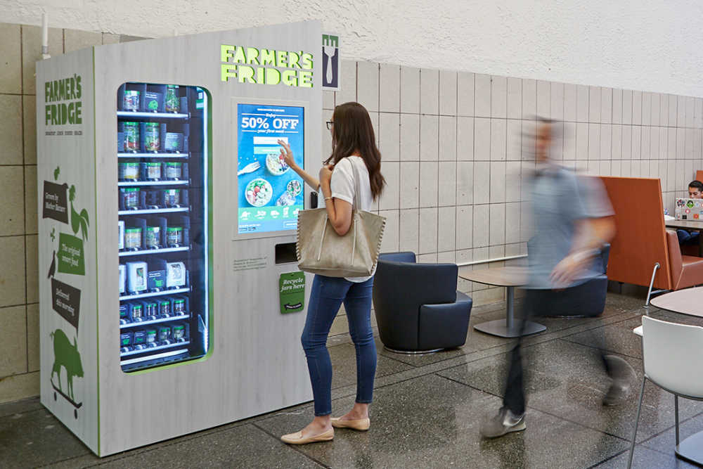 Woman using the touchscreen on a Farmer's Fridge.