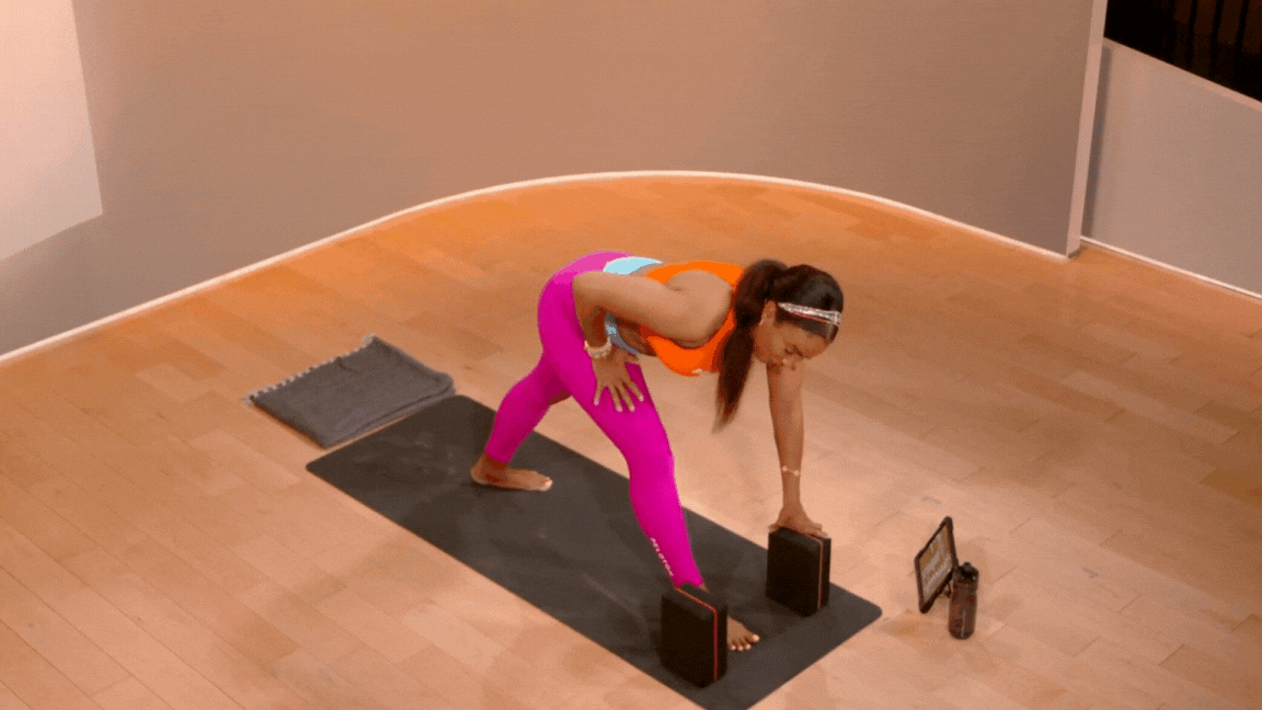 Peloton instructor Chelsea Jackson Roberts demonstrates revolved pyramid or triangle pose during a Peloton yoga class.