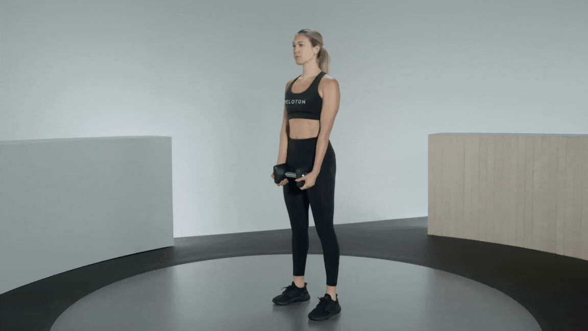 Peloton instructor Callie Gullickson demonstrates a dumbbell good morning exercise with proper form as a great hamstring exercise
