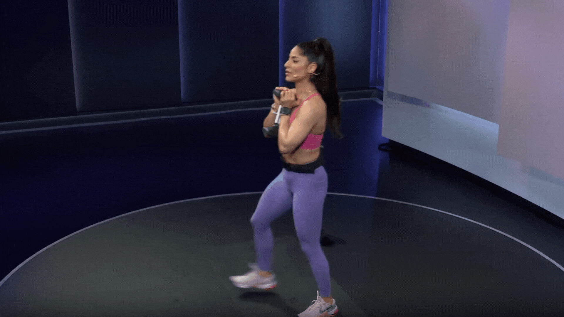 Assal Arian doing forward lunges while holding a dumbbell 