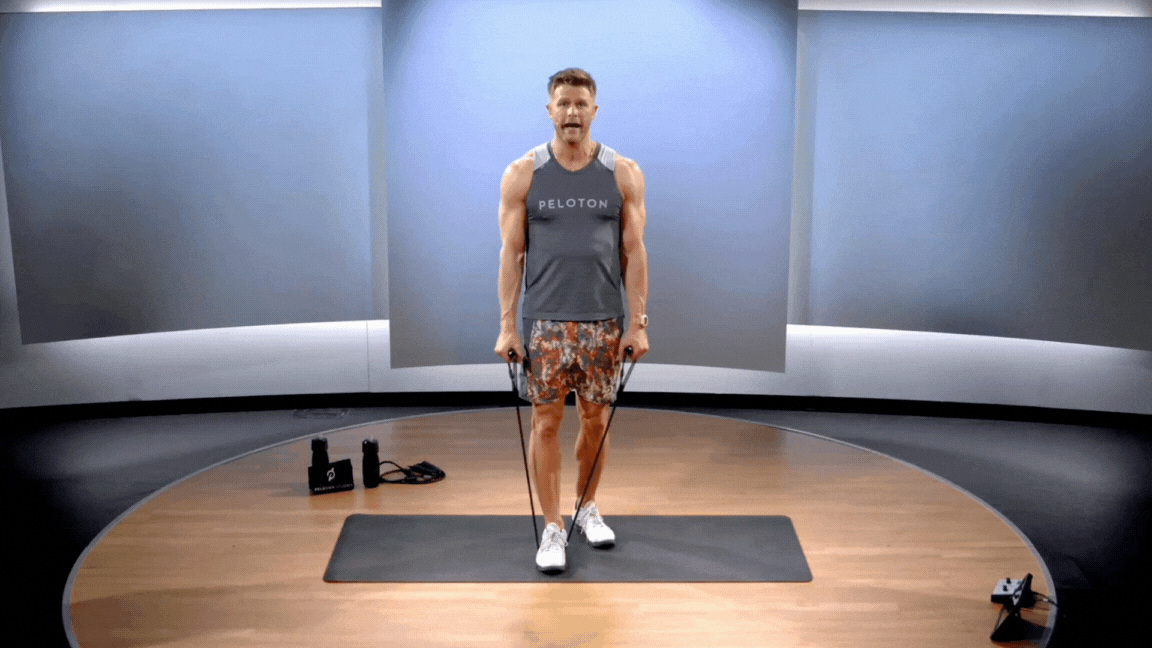 Peloton instructor Andy Speer demonstrates a resistance band front and lateral raise.